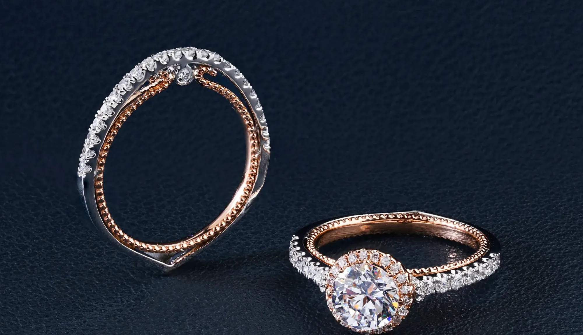 Dos anillos de oro rosa con brillantes sobre fondo azul noche